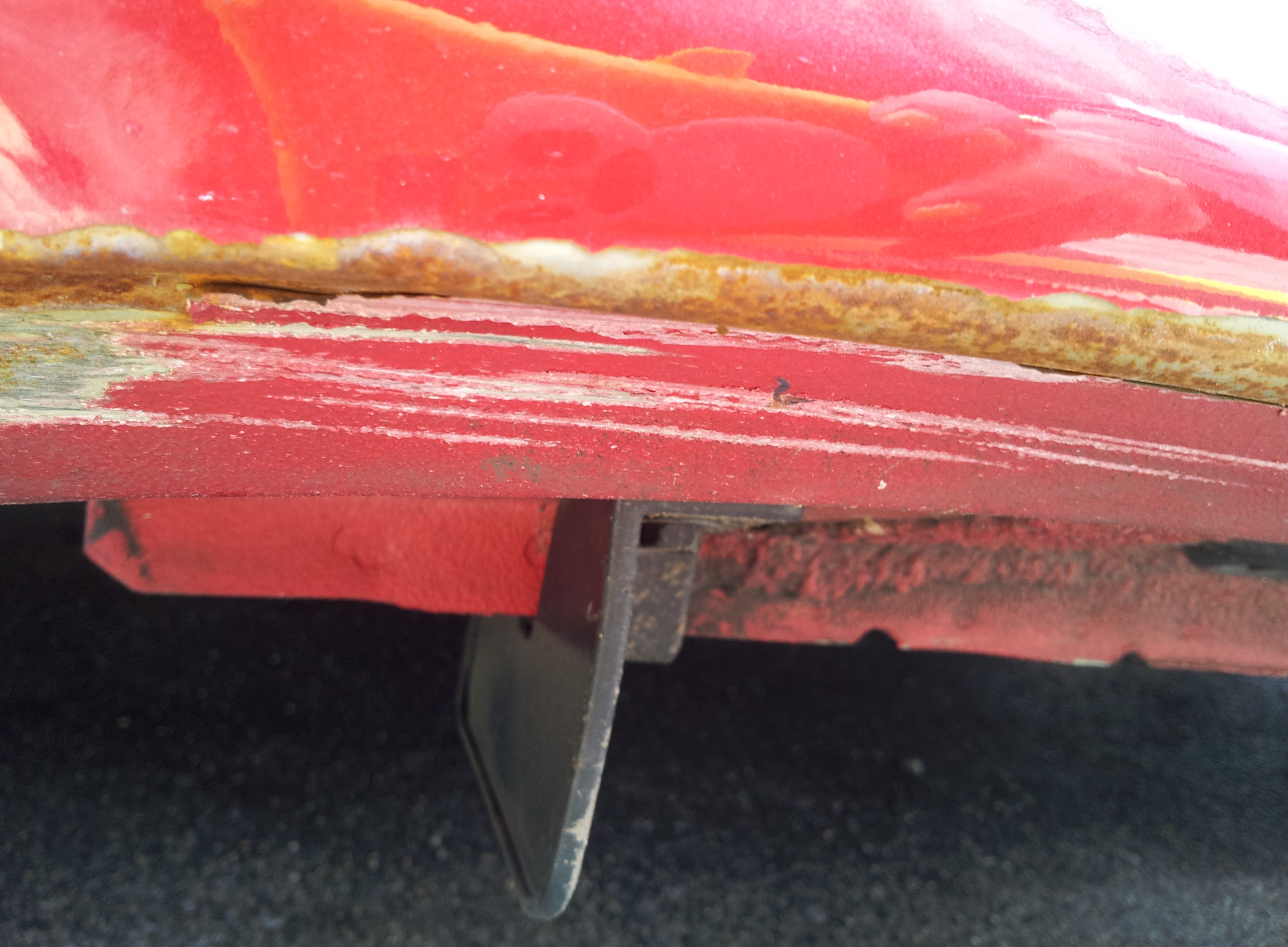 old rusty scratch near passenger rear rocker panel