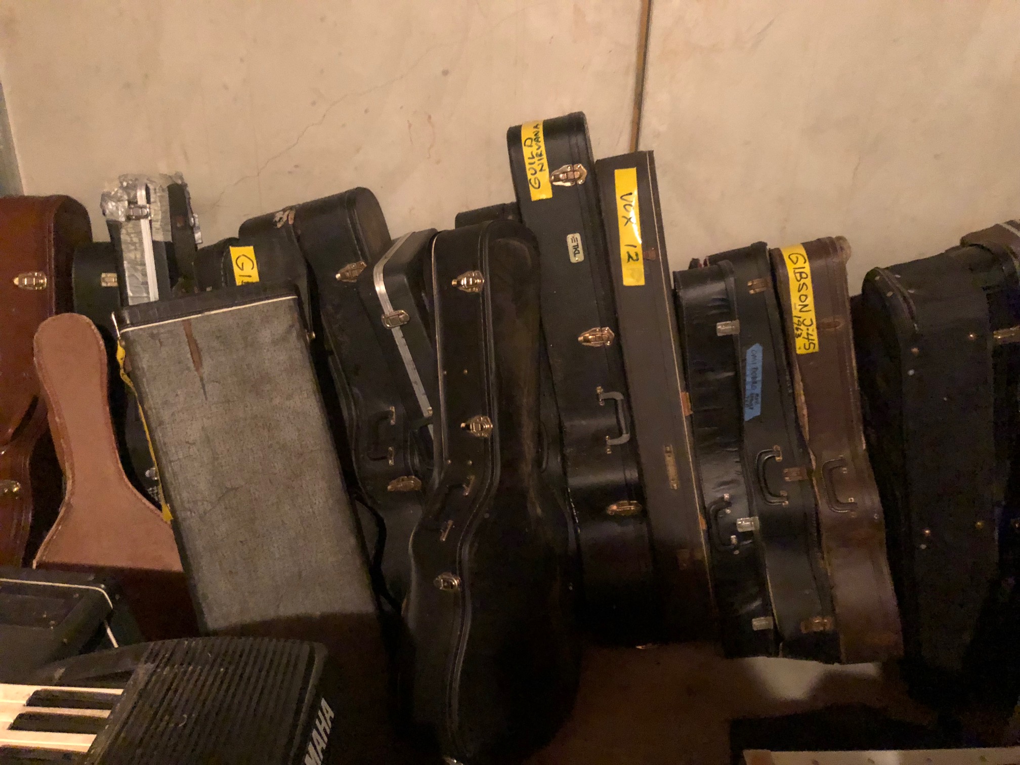 entire back wall labeled guitars cases - all empty