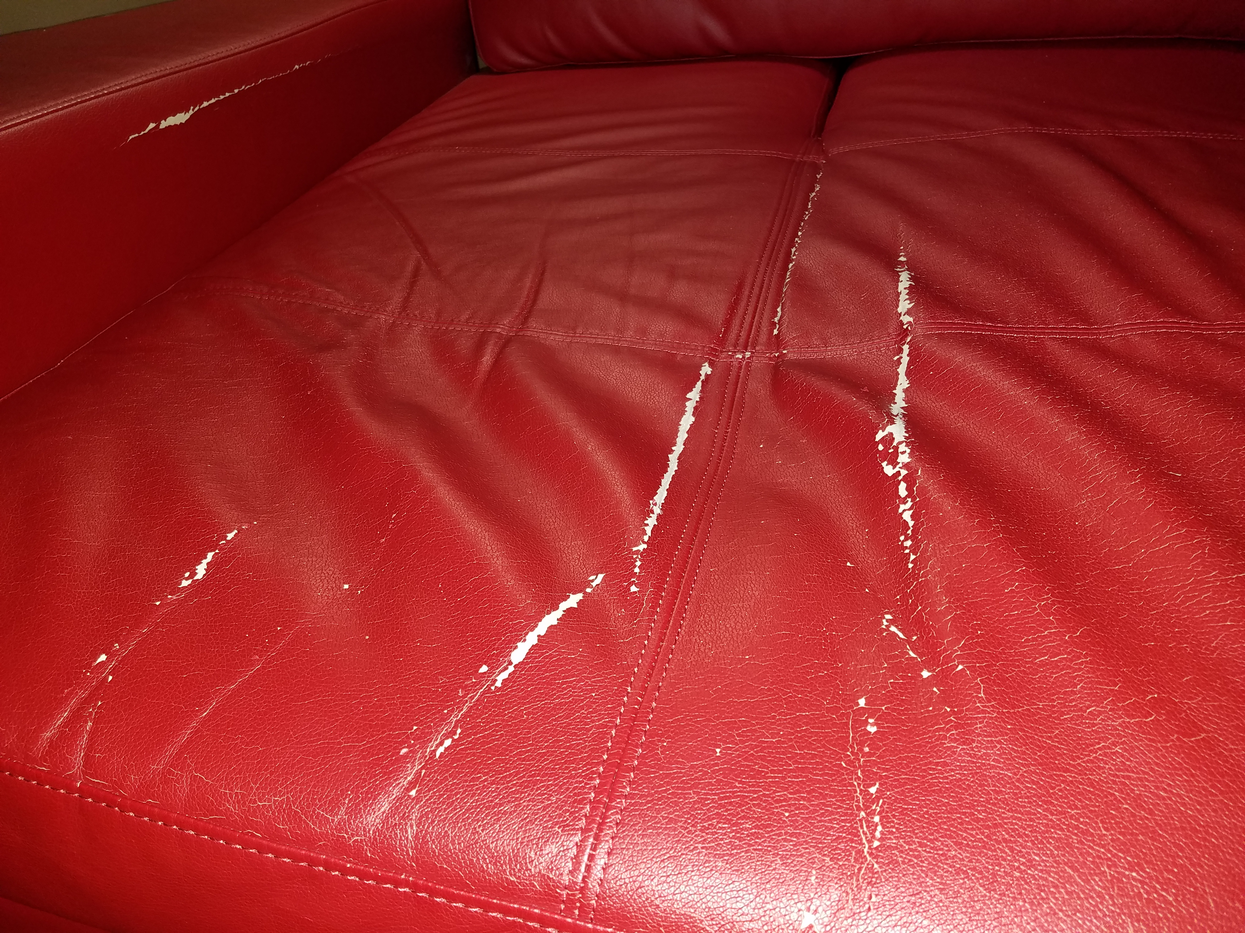 Actual damage to the sectional sold to me as real leather by Marlo. Now that it is cracking and the paint is coming off, one can see it is actually not leather. 