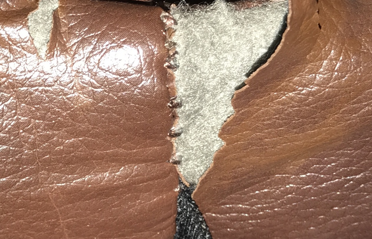 Underside of footrest where leather has deprecated from the stitches 